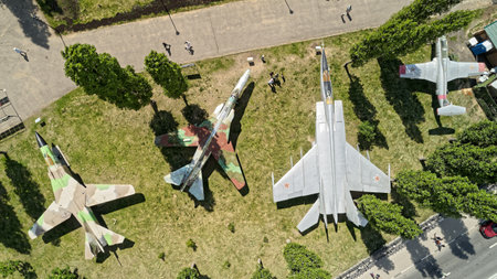 Group of fighter jets are on display in a grassy field. The planes are arranged in a row, with one...