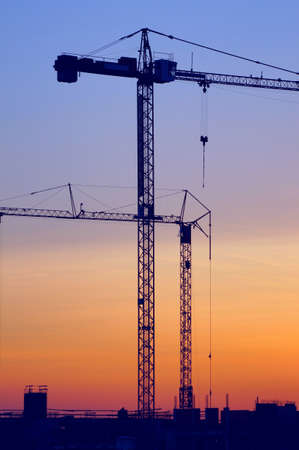 Two cranes standing over the construction yardの写真素材