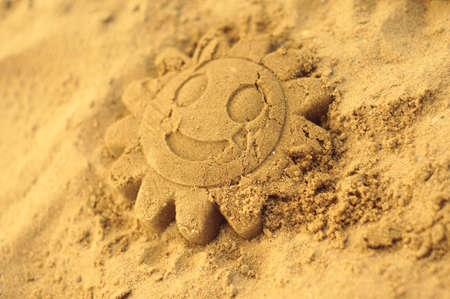 Smiling sun in the sand on the playgroundの写真素材
