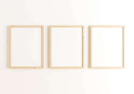 Triple 8x10 Vertical Wood Frame mockup on white wall. Empty picture frame mockup on white background. 3D Rendering.の写真素材