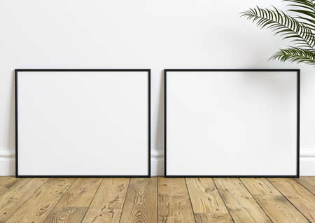 Black horizontal frame mockup on wooden floor with green plant in a vase and white wall behind it. Empty poster frame mockup with plant. Empty picture frame mockup on wooden floor and white backgroundの写真素材