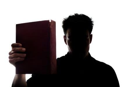 Man figure in silhouette showing a book isolated on white backgroundの写真素材