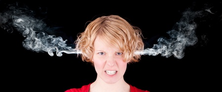 Very angry woman with smoke isolated on black backgroundの写真素材