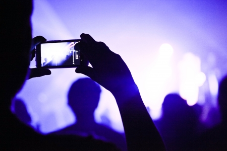 Someone talking a picture during a concert with a phoneの写真素材