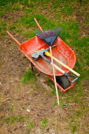 Old Wheelbarow with axepick, shovel and rakeの写真素材