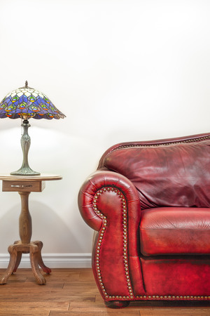 Luxurious Red Leather Couch and Lamp Details in front of a blank wall to ad your text, logo, images, etc.の写真素材