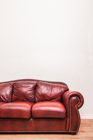 Luxurious Red Leather Couch in front of a blank wall to ad your text, logo, images, etc.の写真素材