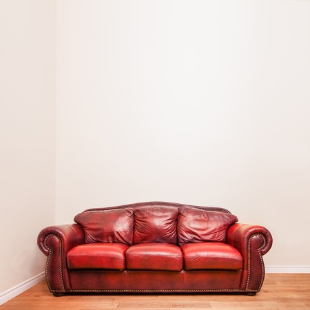 Luxurious Red Leather Couch in front of a blank wall to ad your text, logo, images, etc.の写真素材