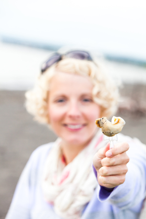Young Woman Eating a prepared and out of the shell Whelk (bourgot in french)の写真素材