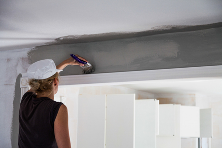 Woman Painting the Edges of the Ceiling with Paintbrushの写真素材