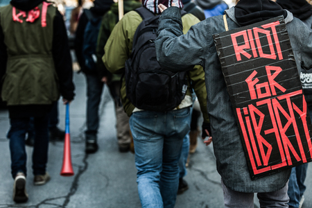 MONTREAL, CANADA, APRIL 02 2015. Riot in the Montreal Streets to counter the Economic Austerity Measures.  Closeup of the Back of a protester Wearing a Sign Saying "Riot For Liberty".のeditorial素材