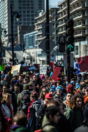MONTREAL, CANADA, APRIL 02 2015. Riot in the Montreal Streets to counter the Economic Austerity Measures. Crowd with Placard, Flags and Signs Walking in the Streetsのeditorial素材