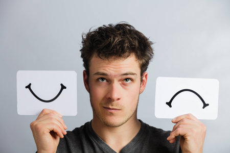 Portrait of a Questioning Man Holding Happy and Unhappy Survey Mood Boardの写真素材