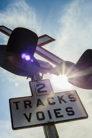 Two Train Track Sign and Light with Sunlight in Backgroundの写真素材
