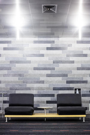 Very Modern Couch Setup in Front of a Gray Brick Wallの写真素材