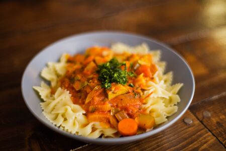 Home made plate of bow shaped pasta with tomato sauce