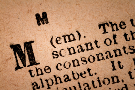 October 1st, 2015 - Montreal, Canada. Close-up of a M, the 13th Letter of the Latin Alphabet into a Old Pronunciation Dictionary October 1st, 2015 - Montreal, Canada. Close-up of a M, the 13th Letter of the Latin Alphabet into a Old Pronunciation Dictionary