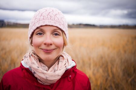 Happy Young Woman Portrait during cold Autumn day In a Fieldの写真素材