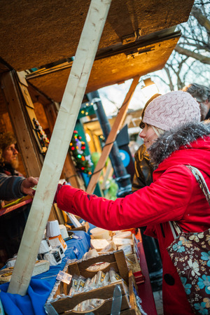 Longueuil, CANADA - December 22nd 2015. Christmas Market Taking Place in a Park. More than Fifty Vendors Present. Young Woman Buying Presents.のeditorial素材