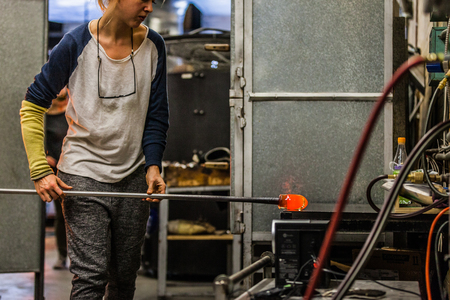 Blowing Glass Professional Woman Adding Pigments to a Blown Glassの写真素材