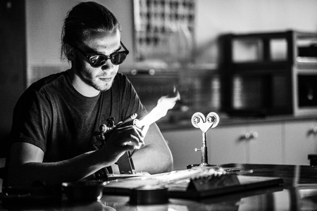 Glassblowing Professional Working on a Torch Flame with Glass Tubesの写真素材