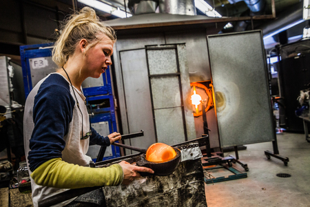 Glass Blowing Workshop - Two Women Shaping glass on the Blowpipeの写真素材