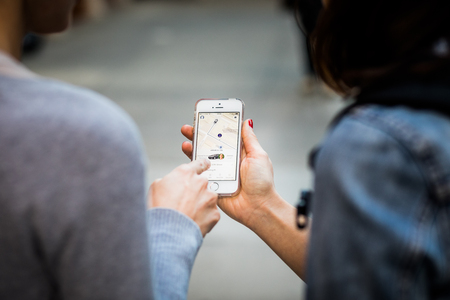NEW YORK, USA - October 13, 2016. Two people in New York looking at their Phone and waiting for Lyft Taxi Driver to Arriveのeditorial素材