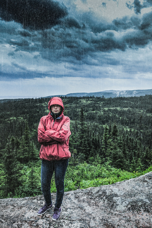 Unpredictable Heavy Rain Pouring on a Sad and Frustrated Young Woman Alone on top of a Mountain.