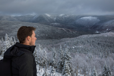Young Man Alone on top of Mountain during Winterの写真素材