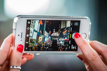 NEW YORK, USA - October 14, 2016. Someone Taking a Picture with a iPhone of Times Square at Night in Manhattan, New York.のeditorial素材