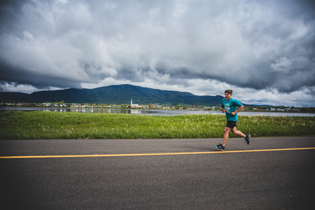 CARLETON, CANADA - June 4, 2017. During the 5th Marathon of Carleton in Quebec, Canada. Lonely Man Leading a Group of 10K Runnersのeditorial素材