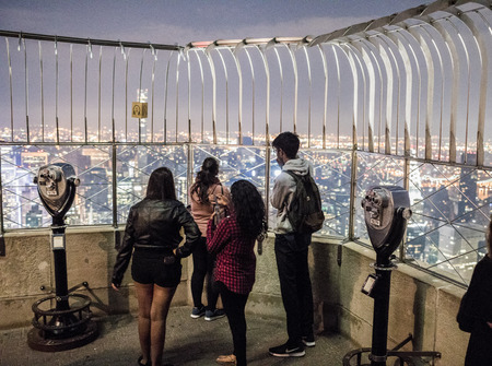 NEW YORK, USA - October 17, 2016. Tourists and Binoculars on top of Empire State Building at Night in Manhattan, New Yorkのeditorial素材