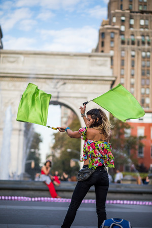 NEW YORK, USA - October 17, 2016. Woman Juggling with Flags, in the Middle of Washington Square Park, Greenwich Park in New York City.のeditorial素材