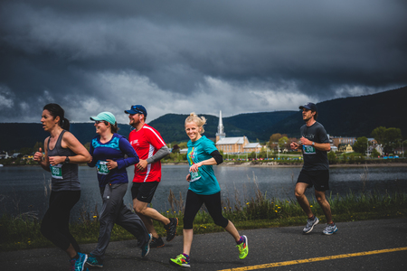 CARLETON, CANADA - June 4, 2017. During the 5th Marathon of Carleton in Quebec, Canada. Older Woman in top Shape running with a group of Young peopleのeditorial素材