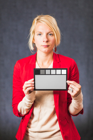Adult blonde woman looking at camera and holding gray palette color board.の写真素材