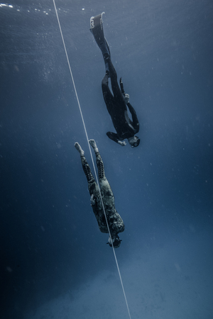 SAN ANDRES ISLAND, Colombia _ Circa March 2017. Freediver and his Safety Diver Diving and Following the Life Line at all time in the Deep Blue of San Andres Island, Colombia.のeditorial素材