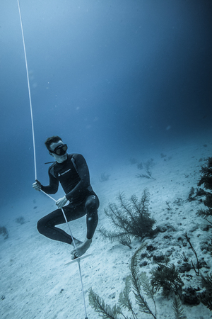 SAN ANDRES ISLAND, Colombia _ Circa March 2017. Freediver at the Bottom of the line Looking at the Corals and doing a Breath Holdingのeditorial素材
