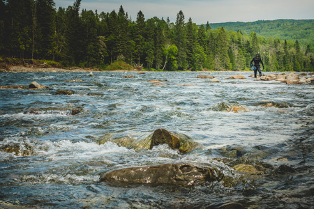 BONAVENTURE, CANADA _ JULY 19, 2017. Man Walking on the Rock with Snorkeling Gear in Hands at the Riverのeditorial素材