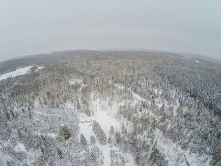 Aerial View of Forest and Little Canadian Log Wood Shack during Winter in Quebec, Canadaの写真素材