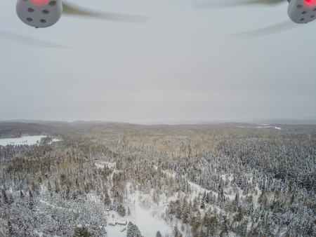 Quadcopter View of Forest and Little Canadian Log Wood Shack during Winter in Quebec, Canadaの写真素材