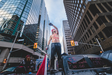 Ottawa, Ontario, Canada - January 30 2022. Happy Shirtless Man Waving Canadian Flag in the Cold for the Convoy for Freedom 2022 Trucks and Tracors Protestのeditorial素材