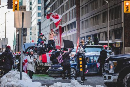 Ottawa, Ontario, Canada - January 30 2022. Happy Shirtless Man Waving Canadian Flag in the Cold for the Convoy for Freedom 2022 Trucks and Tracors Protestのeditorial素材