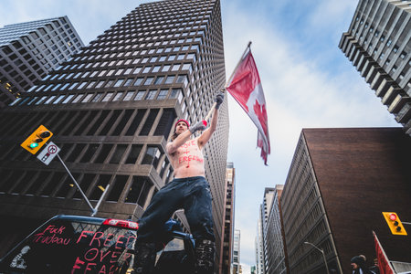 Ottawa, Ontario, Canada - January 30 2022. Happy Shirtless Man Waving Canadian Flag in the Cold for...