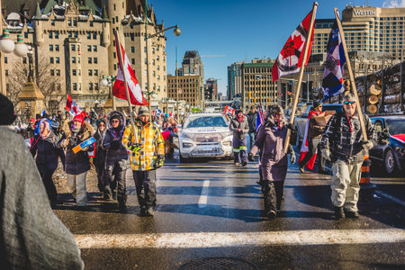 Ottawa, Ontario, Canada - January 29 2022. Protesters Marching in Ottawa Convoy for Freedom 2022 Protesting in the Streets with Flag, Signs and Smiles.のeditorial素材