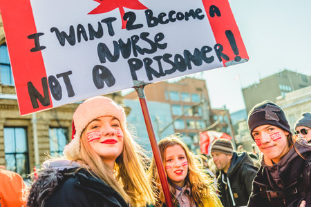 Ottawa, Ontario, Canada - January 29 2022. Protesters in Ottawa Convoy for Freedom 2022 Protesting in the Streets with Flag, Signs and Smiles.のeditorial素材