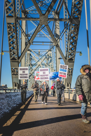 Ottawa, Ontario, Canada - February 01 2022. Protesters crossing the Ottawa Bridge to join the Freedom Convoy on the Parliament Hill on cold day of Winter.のeditorial素材