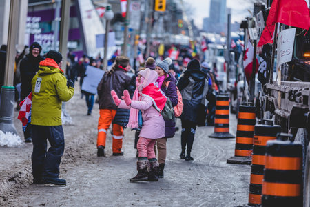 Ottawa, Ontario, Canada - January 30 2022. Protesters in Ottawa Convoy for Freedom 2022 Protesting in the Streets with Flag, Signs and Smiles.のeditorial素材