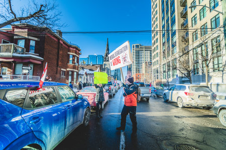 Ottawa, Ontario, Canada - January 29 2022. Protesters in Ottawa Convoy for Freedom 2022 Protesting in the Streets with Flag, Signs and Smiles.のeditorial素材