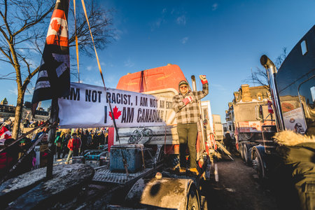 Ottawa, Ontario, Canada - January 29 2022. Protesters in Ottawa Convoy for Freedom 2022 Protesting in the Streets with Flag, Signs and Smiles.のeditorial素材
