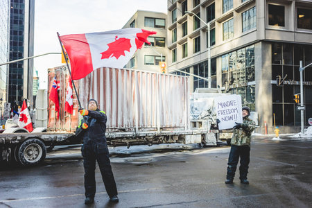 Ottawa, Ontario, Canada - January 30 2022. Protesters in Ottawa Convoy for Freedom 2022 Protesting in the Streets with Flag, Signs and Smiles.のeditorial素材